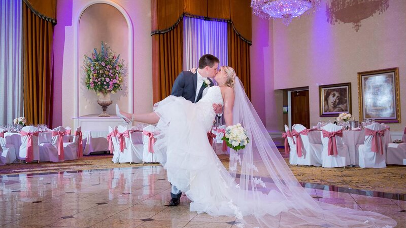 Bride in grooms arms. Kissing.