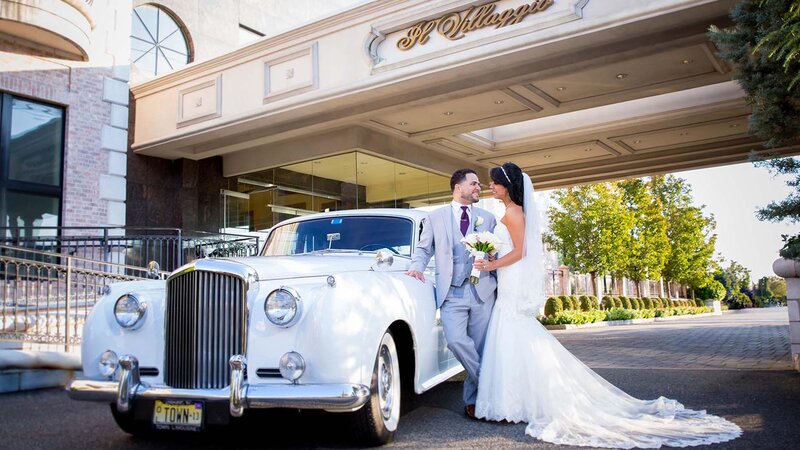 Bride & Groom standing against car