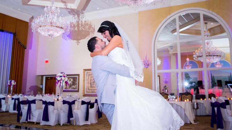 Groom holding bride in ballroom