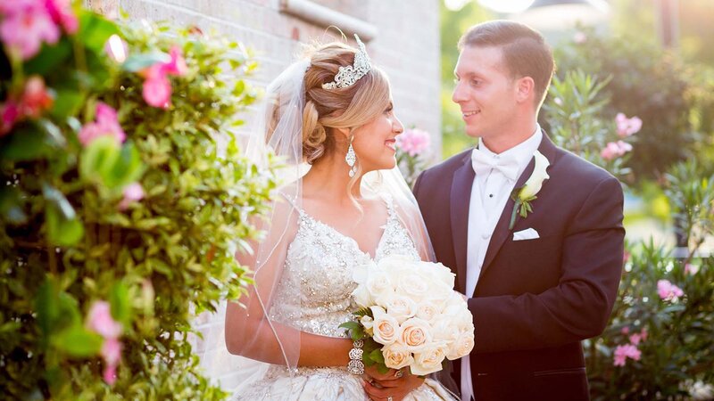 Bride & groom looking at each other outdoors.