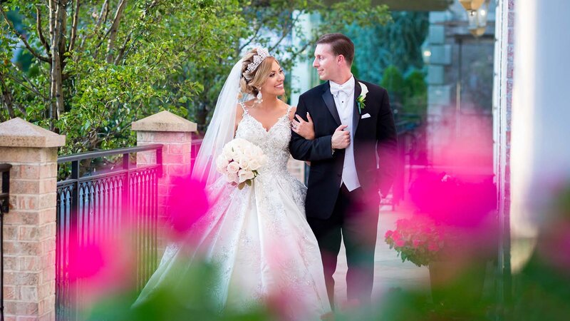 Bride & Groom walking arm in arm outdoors.