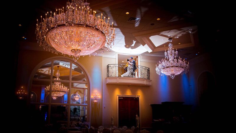 Bride and groom on balcony kissing.