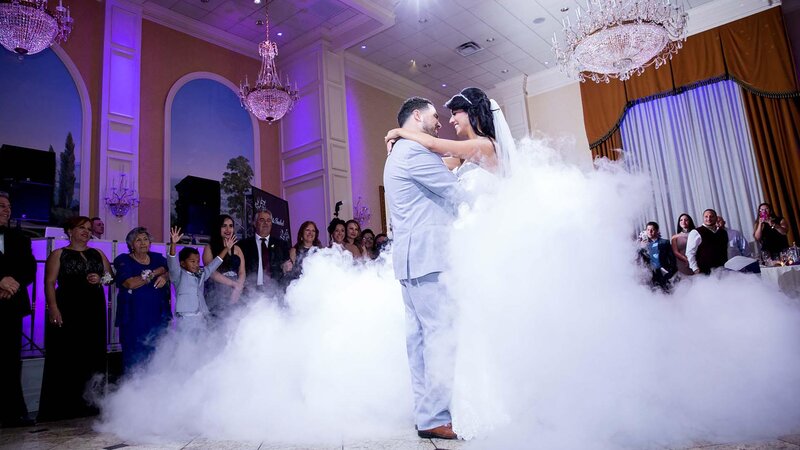 Bride and groom dancing with people watching.